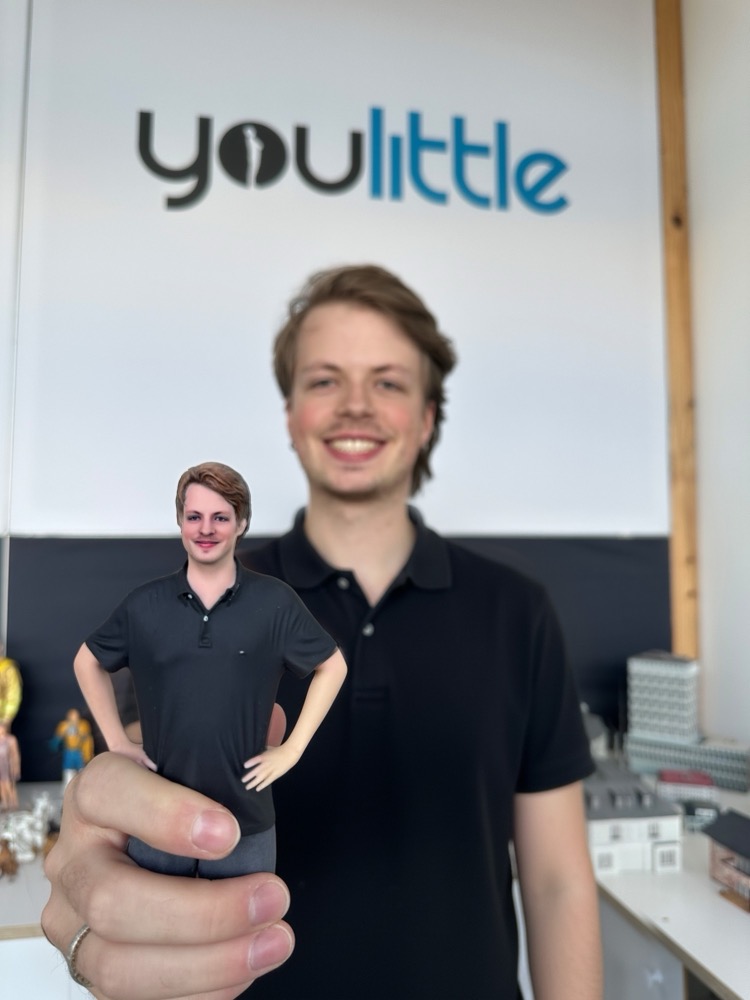 Ein Mann hält seine gedruckte 3D-Figur in der Hand