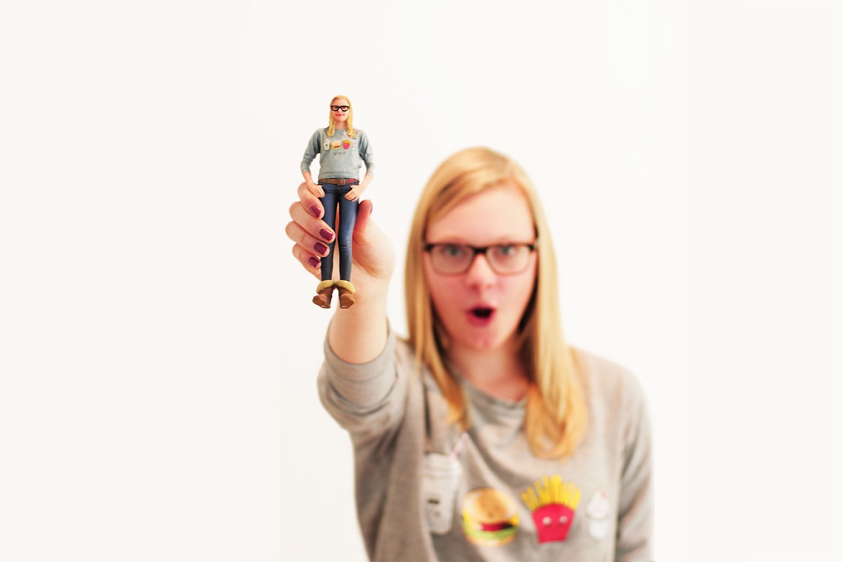Junge Frau hält ihre eigene 3D-Figur in der Hand